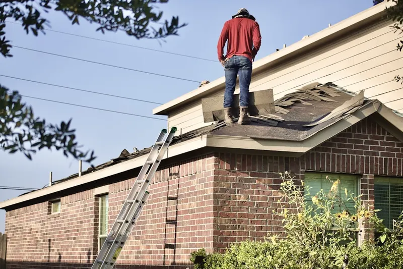 Professional roofer working on a residential roof in Yoman